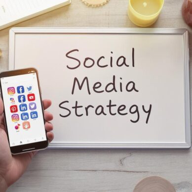 a smartphone displaying various social media app icons including Instagram, Facebook, Twitter, Pinterest, YouTube, and LinkedIn.